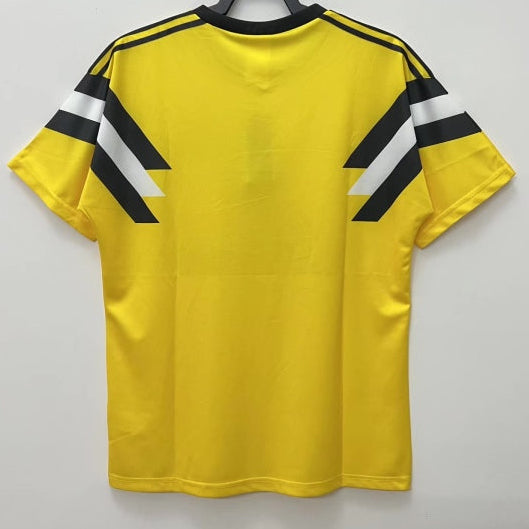 Yellow 1988 Borussia Dortmund dfb-pokal final football shirt with black and white stripes on a hanger against a gray background