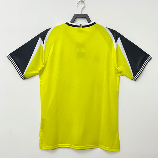 Yellow Dortmund 95/96 home shirt with black and white accents on a hanger against a white background