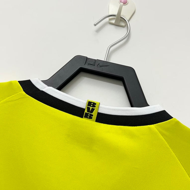 Yellow Dortmund 95/96 home shirt with black trim and 'BVB' logo on a hanger against a white background