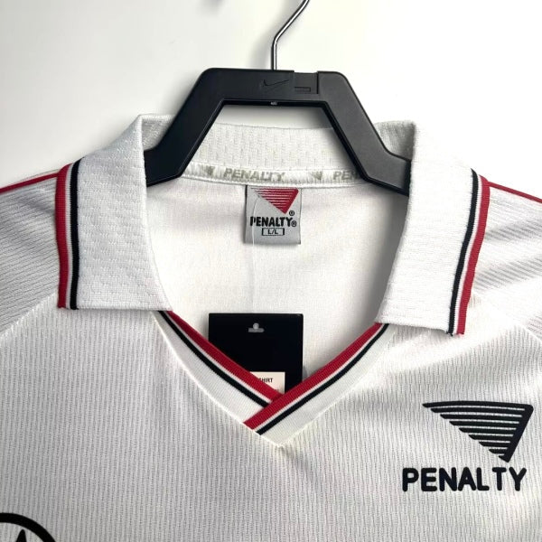White 2000 São Paulo home shirt with red and black accents on a hanger, featuring Penalty branding.