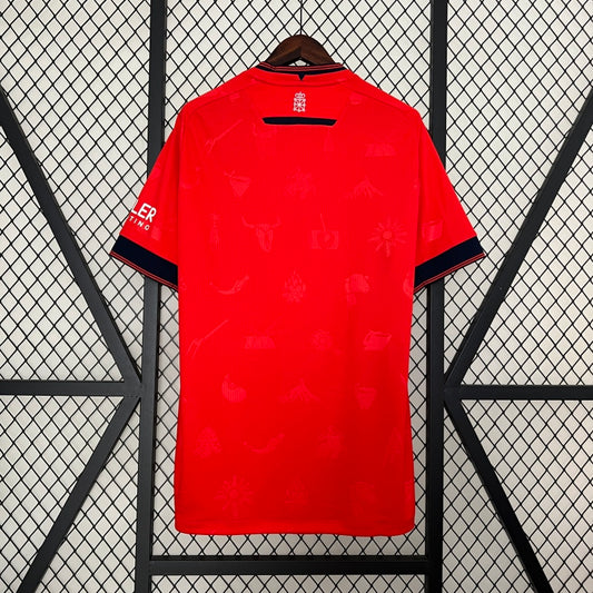 Red Osasuna 96/97 home shirt with black accents on a hanger against a black metal grid background