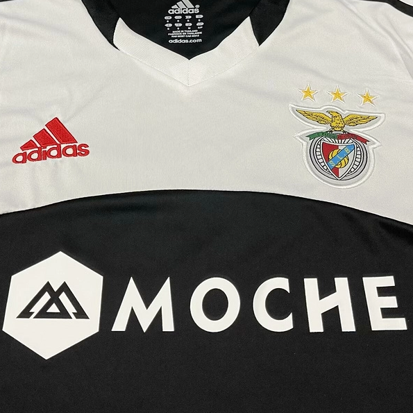 White and black Benfica 13/14 away shirt with Adidas and Moche logos on a gray background
