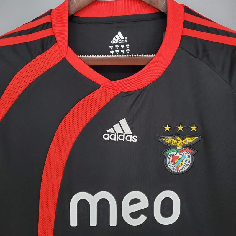 Black Benfica 09/10 away shirt with red accents, Adidas logo, and Benfica emblem on a hanger.