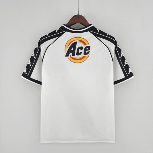 White Vasco de gama 2000 away shirt  with black sleeves and 'Ace' logo on a hanger against a gray background