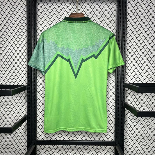 Green Celtic 91/92 away shirt  with a geometric design on a black metal rack.