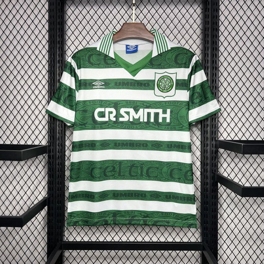 Green and white striped Celtic 95-97 home shirt with 'CR Smith' text, hanging on a rack.