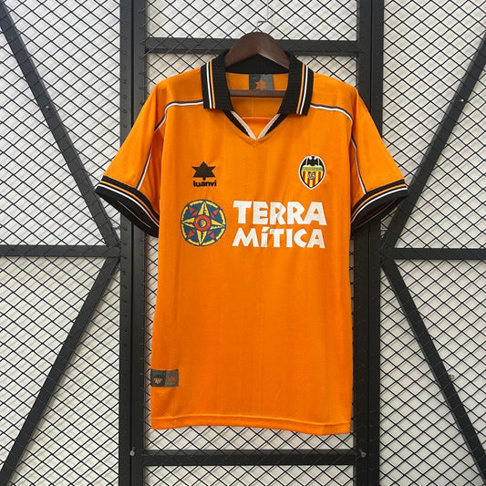 Orange Valencia 99/00 away shirt with 'Terra Mítica' branding on a hanger against a grid background