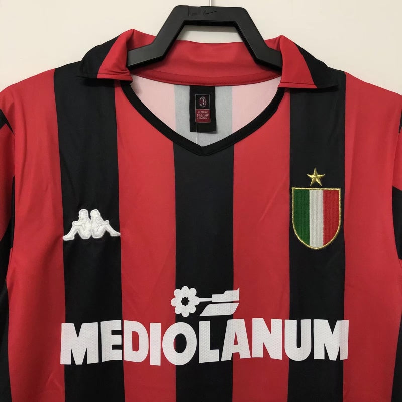 Red and black striped Ac Milan 88/89 home shirt with Mediolanum logo on a hanger