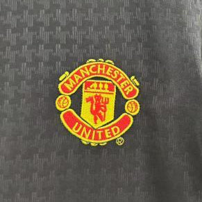 man United 03/04 away shirt with Manchester United logo on a hanger