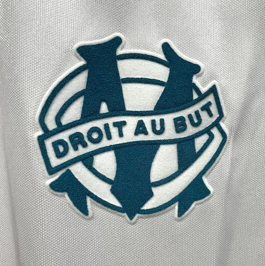 Logo with 'Droit Au But' text on a Marseille 92/93 home shirt