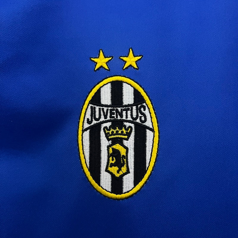 Juventus logo on a blue Juventus 99/00 away shirt