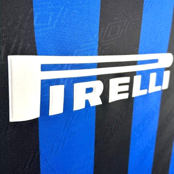 Close-up of a Inter Milan 95/96 home shirt with Pirelli logo on a black and blue striped background