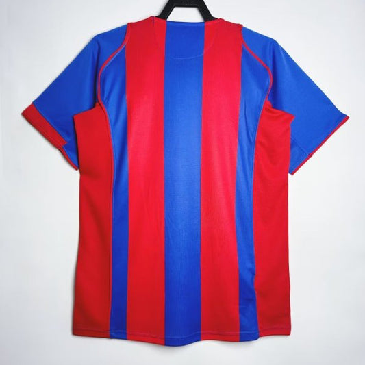 Red and blue striped Barcelona 04/05 home shirt on a hanger against a white background