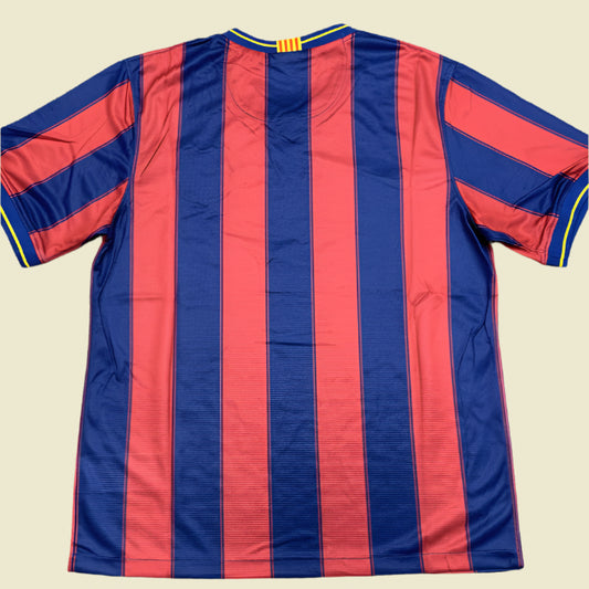 Blue and red striped Barcelona 09/10 home shirt on a gray surface