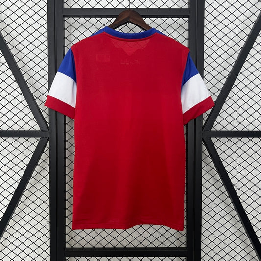 Red USA 2014 away shirt with blue and white sleeves on a hanger against a grid background