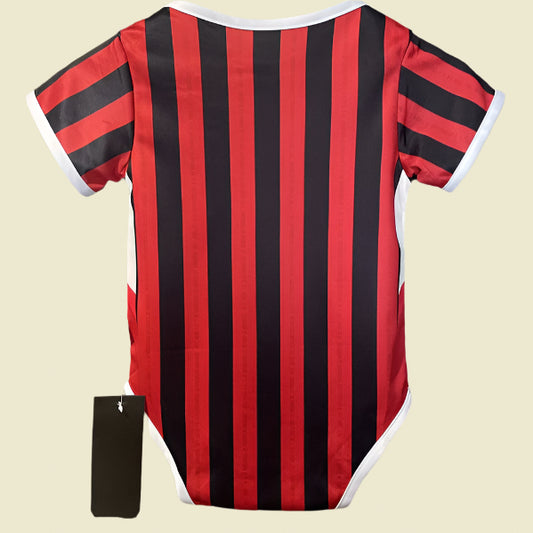 Red and black striped ac Milan 24/25 home baby onesie on a mannequin against a neutral background