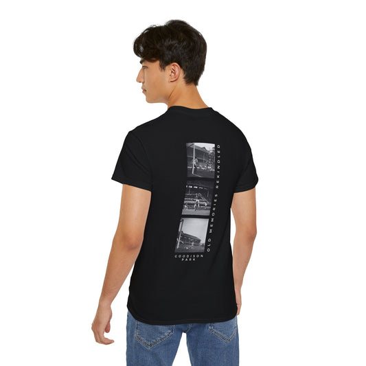 Person wearing a black t-shirt with a graphic design on the back, standing against a white background