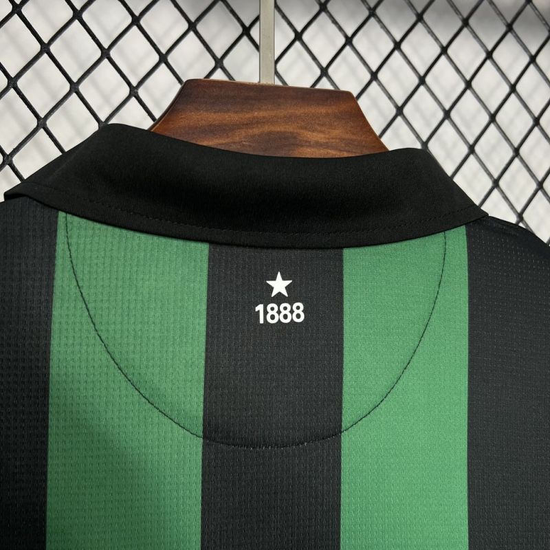 Black and green Celtic 06/07 away shirt with a star and number 1888 on a wooden block against a chain-link fence background.
