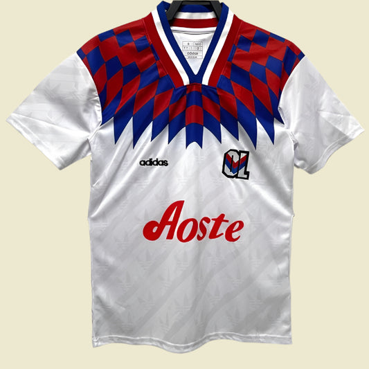 White 95/96 Lyon home shirt with red and blue accents, featuring Adidas logo and 'Aoste' branding, on a white background.