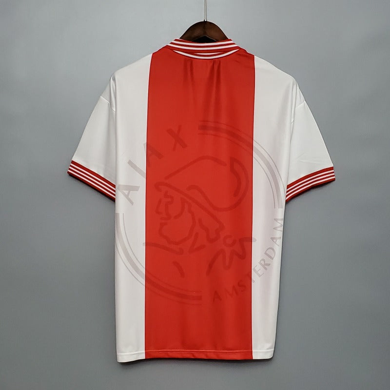 Red and white Ajax 95/96 home shirt on a gray background