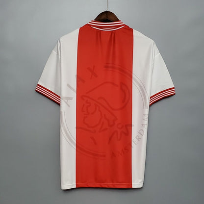Red and white Ajax 95/96 home shirt on a gray background