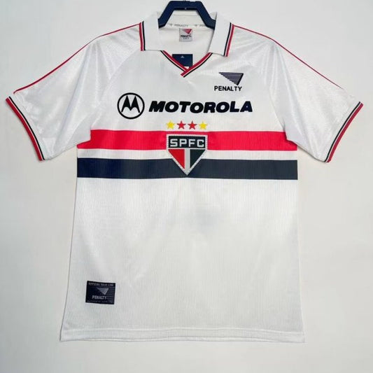 White 2000 São Paulo home shirt with branding on a hanger against a white background