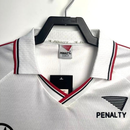 White 2000 São Paulo home shirt with red and black accents on a hanger, featuring Penalty branding.
