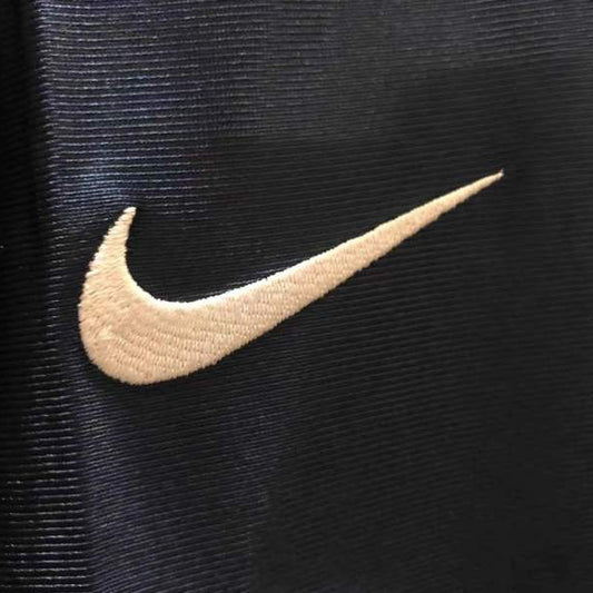 Close-up of a Nike logo on a 01/02 psg home shirt