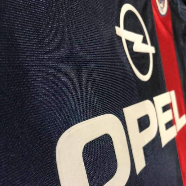 Close-up of a logo with 'Opel' text on a 01/02 psg home shirt