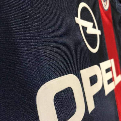 Close-up of a logo with 'Opel' text on a 01/02 psg home shirt
