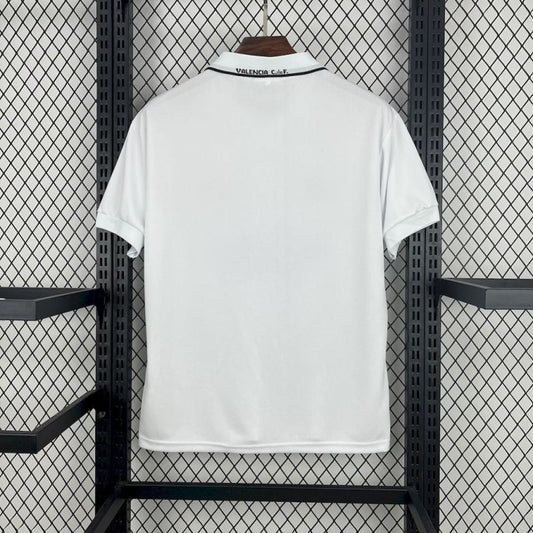 White 96/97 Valencia home shirt with brand logo on a hanger against a grid-patterned wall.