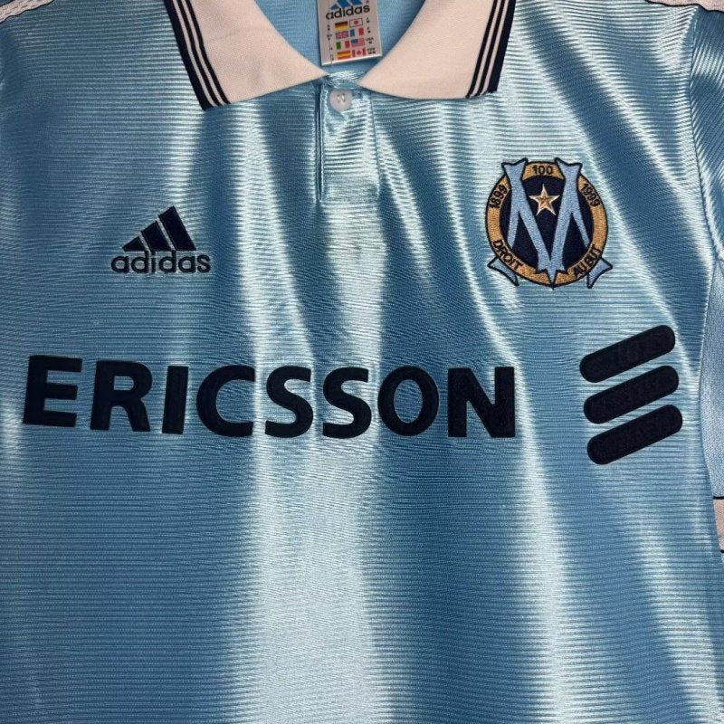 Blue Marseille 98/99 away shirt  with Adidas and Ericsson logos, featuring a club emblem.