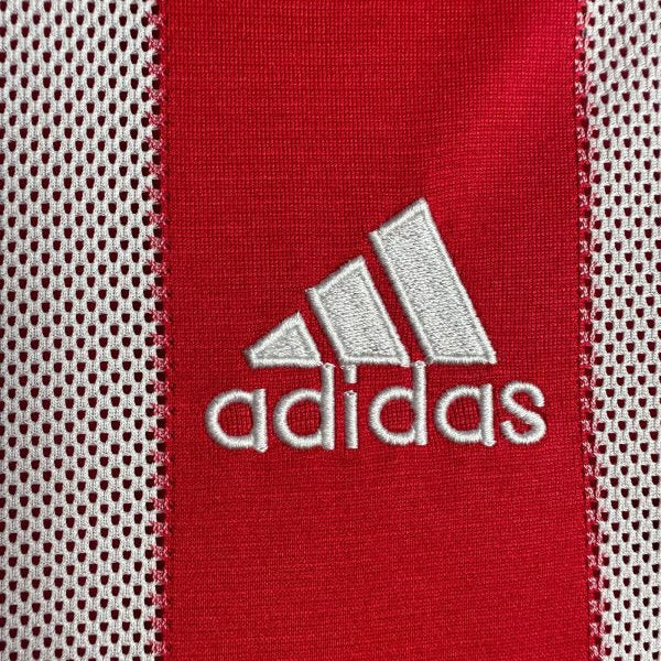 Close-up of Adidas logo on a red and white Bayern Munich 10/11 home shirt