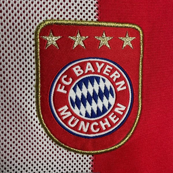 FC Bayern Munich logo on a Bayern Munich 10/11 home shirt with red and white background
