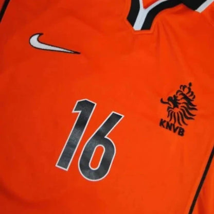 Orange Netherlands 98 World Cup home shirt with number 16 and brand logos on a light gray background