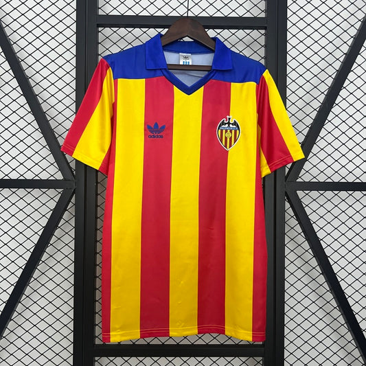 Red and yellow striped Valencia 80-82 away shirt with blue collar on a hanger against a black grid background