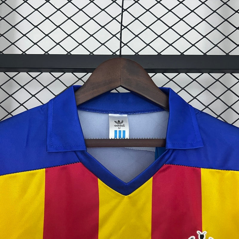Colorful Valencia 80-82 away shirt with Adidas label on a hanger against a grid background