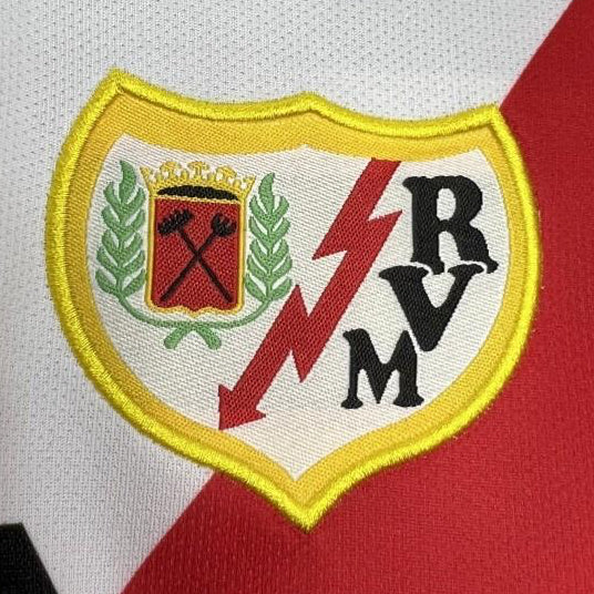 Close-up of a Rayo vallecano 01/02 home shirt with a logo featuring letters and symbols on a white and red background.