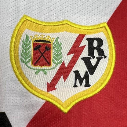 Close-up of a Rayo vallecano 01/02 home shirt with a logo featuring letters and symbols on a white and red background.