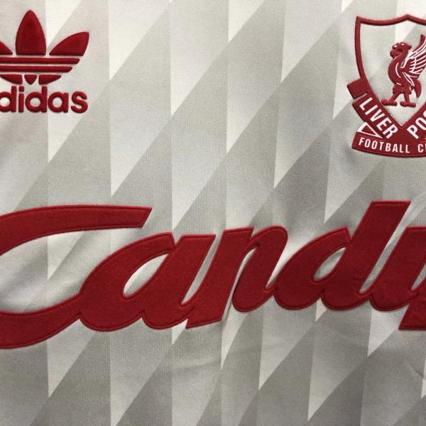 Close-up of a Liverpool 89-91 away shirt with Adidas and Liverpool FC logos on a patterned background
