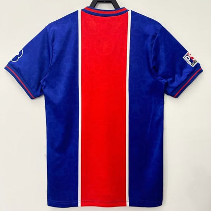 Blue and red psg 95/96 home shirt on a hanger against a white background