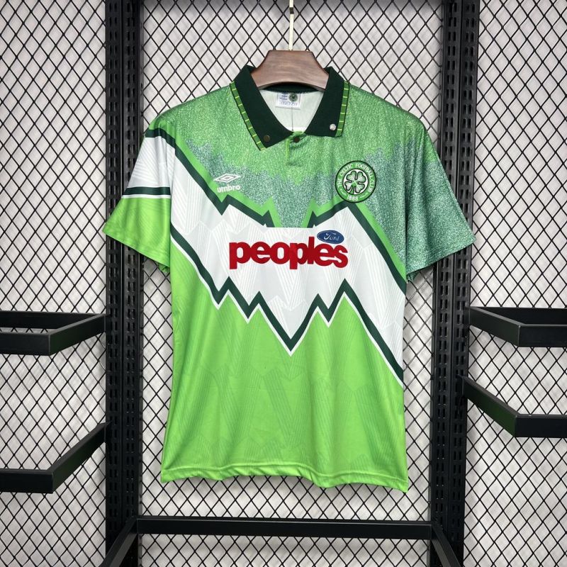 Green and white Celtic 91/92 away shirt with 'peoples' logo on a hanger against a black grid background
