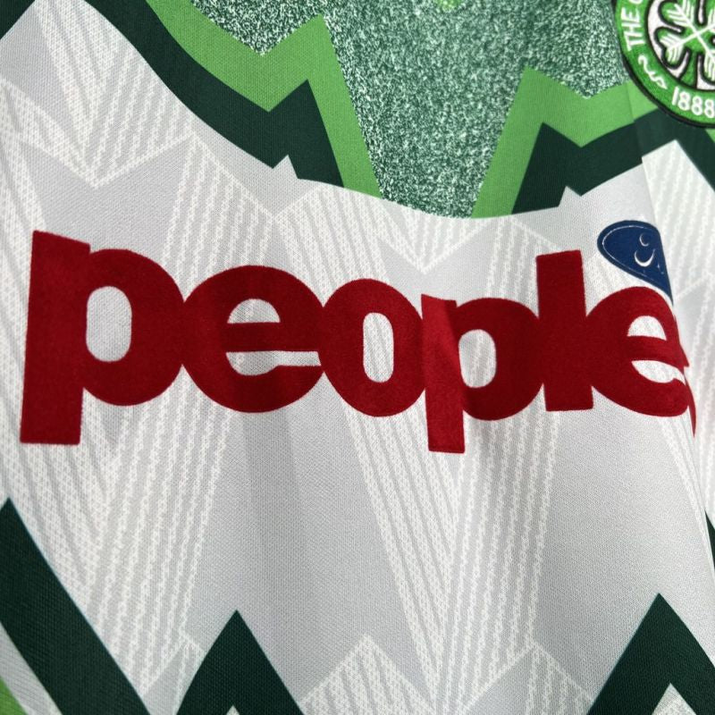 Close-up of a Celtic 91/92 away shirt with 'people’s ford' logo and green and white patterns.
