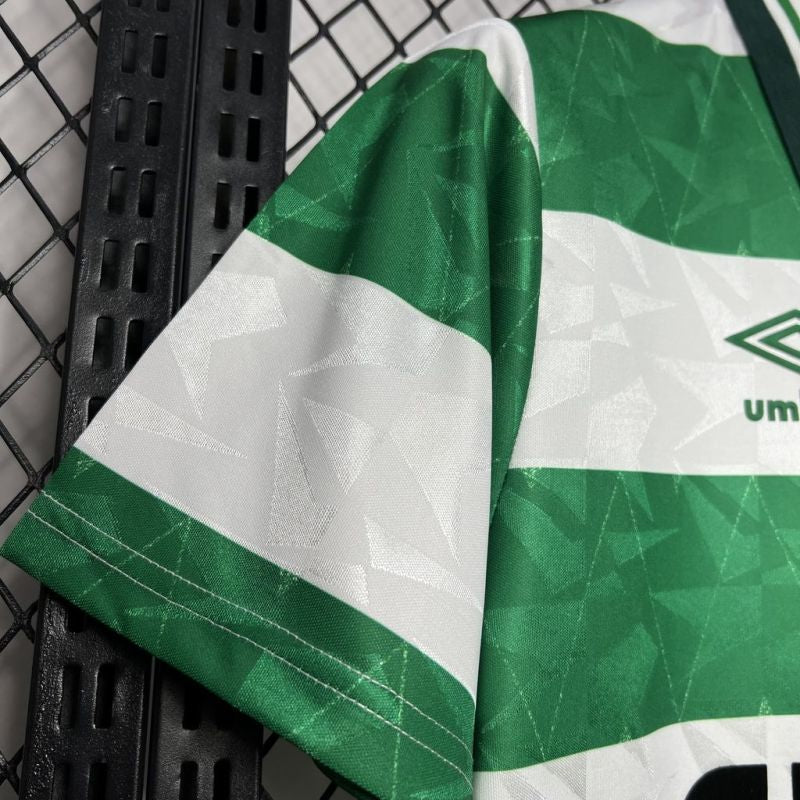 Green and white Celtic 87/88 home shirt with brand logo on a black metal surface