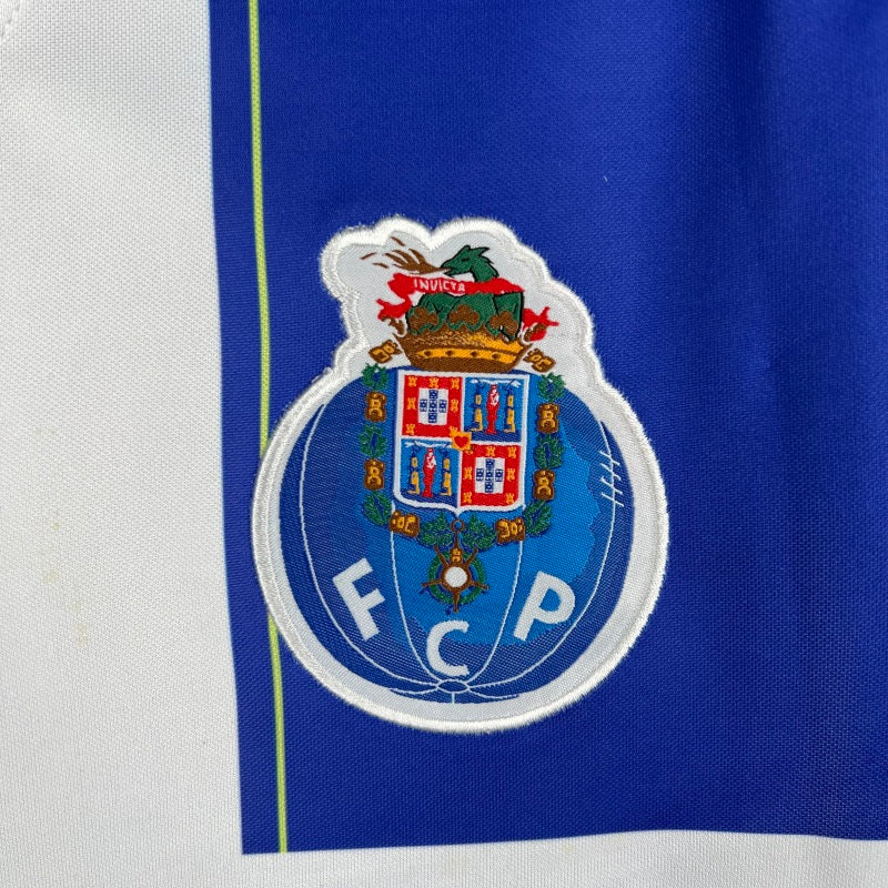 Close-up of a sports team logo on a blue and white Porto 98/99 home shirt
