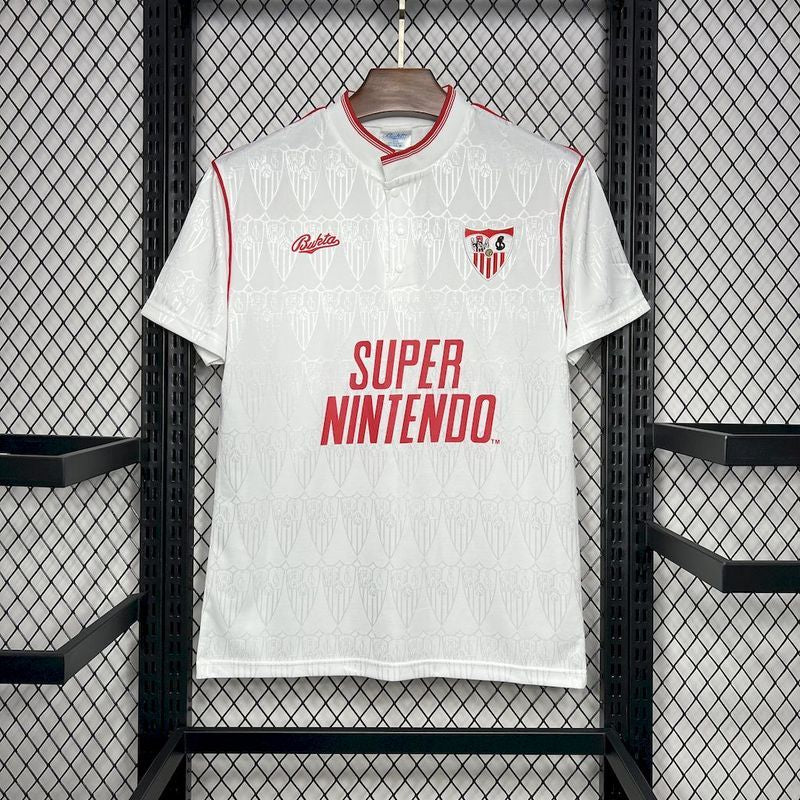 White Sevilla 91/92 Super Nintendo home shirt with red accents and 'Super Nintendo' text, hanging on a rack.