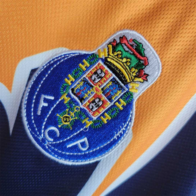 Close-up of a colorful emblem on a Porto 97-99 away shirt  with 'FCP' branding.