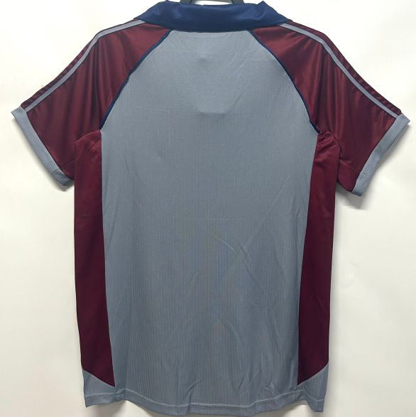Gray and maroon Bayern Munich 98/99 third shirt on a hanger against a white background