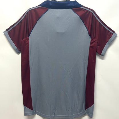 Gray and maroon Bayern Munich 98/99 third shirt on a hanger against a white background