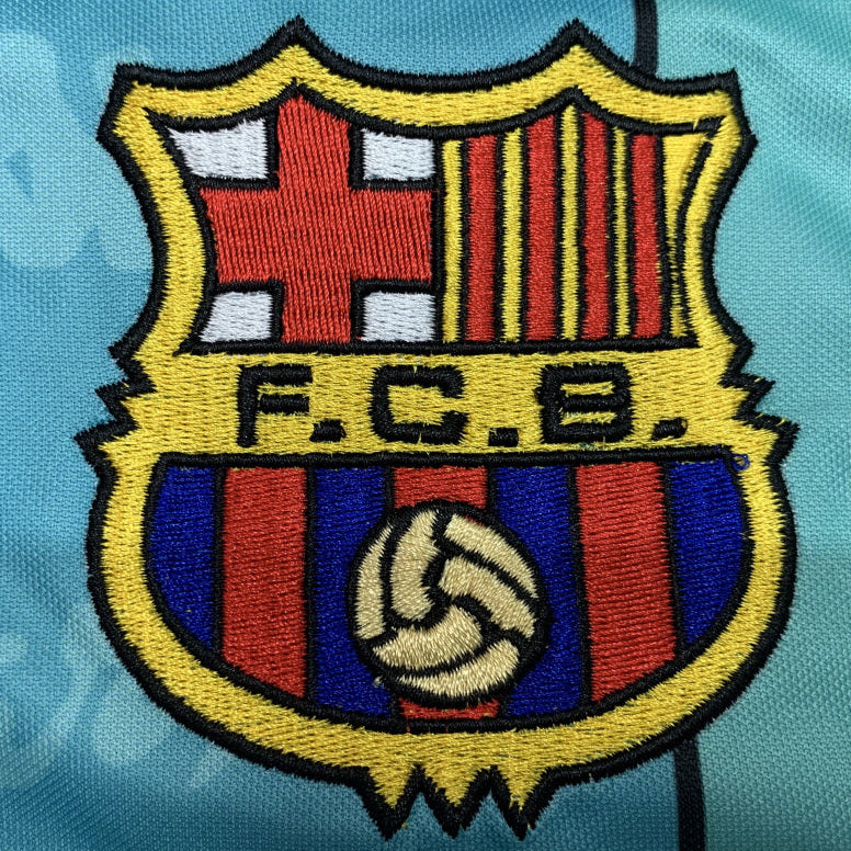 Embroidered FC Barcelona logo on a blue Barcelona 96/97 away shirt